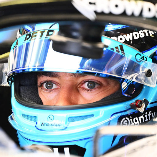 George Russell hunkered down in the Mercedes garage, where only his bright blue helmet shows over the carbon cockpit