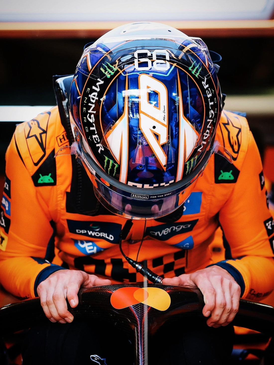 A close-up shot of an artist intricately airbrushing vibrant, detailed neon geometric graphics onto a sleek racing helmet