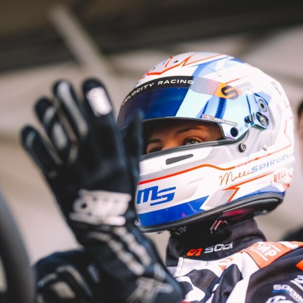 Person wearing a racing helmet and gloves with visible branding