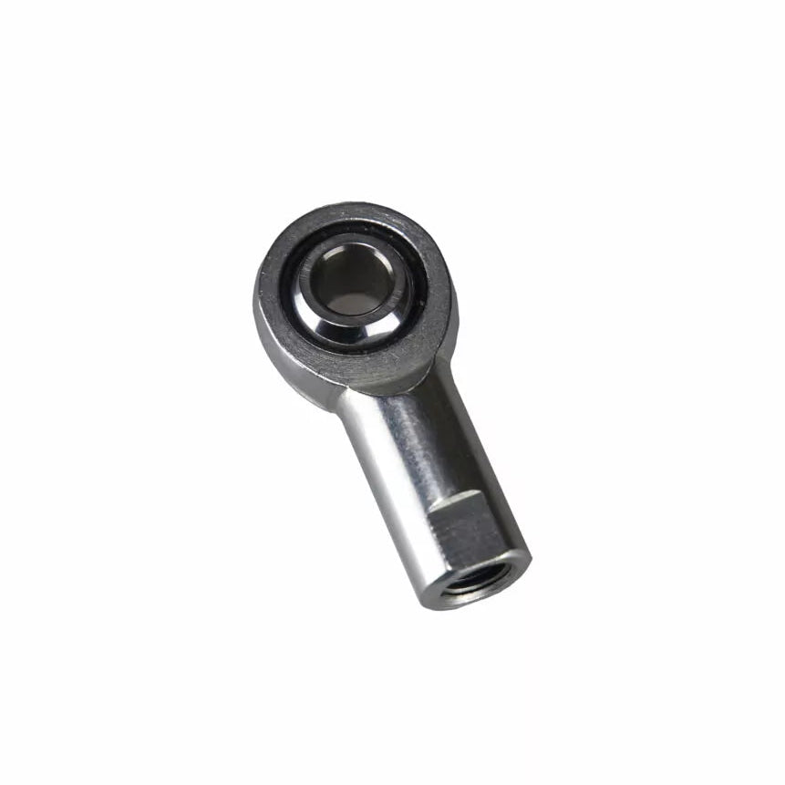 Detailed close-up of a premium zinc-plated steel female spherical rod end by obp Motorsport, showcasing the right-hand internal female threads inside the precision-machined carbon steel hex shank, leading to the embedded hardened steel spherical ball bearing surrounded by a black injection-molded PTFE liner.