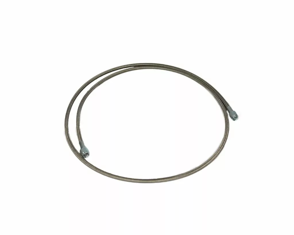 OBP Motorsport stainless steel braided reservoir feed line with a 7/16 UNF female end fitting alongside a male-to-male adapter block. 1620mm long